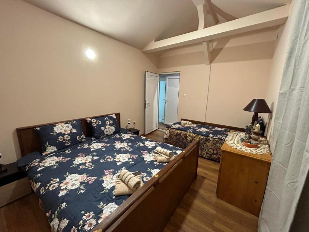 大特尔诺沃Къща за гости Трапезица с безплатен паркинг двор и веранди的一间卧室配有两张床和一张带台灯的桌子