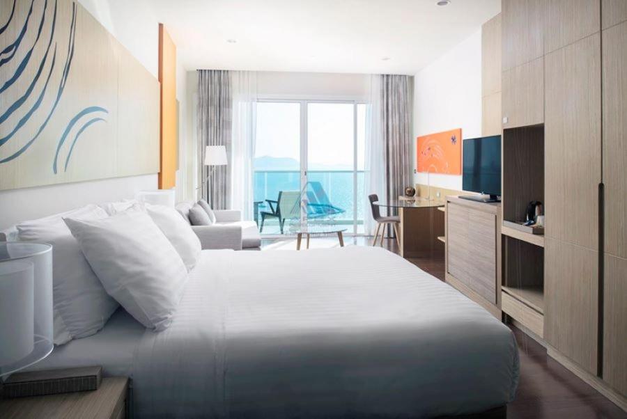 纳仲天ไวท์ แซนด์ บีช เรสซิเดนซ์ พัทยา(White Sand Beach Residences Pattaya)的酒店客房设有一张大床和一间客厅。