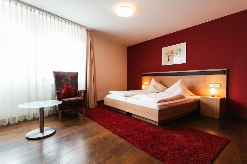 维森布伦施瓦泽尔阿德勒兰德酒店的一间卧室设有一张床和红色的墙壁