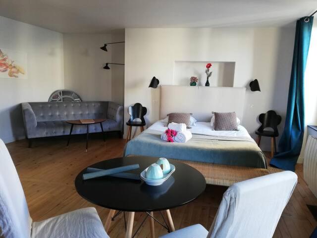 克莱蒙费朗La Tour Grégoire的一间卧室配有一张床、一张桌子和一张沙发