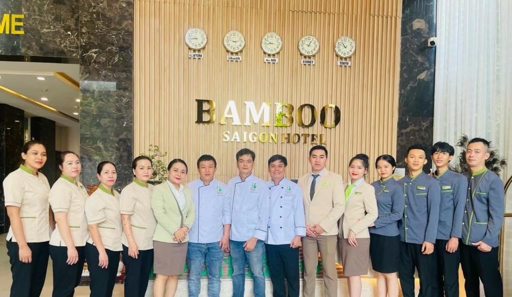 胡志明市Khách sạn Bamboo Sài gòn的一群站在建筑物前的人