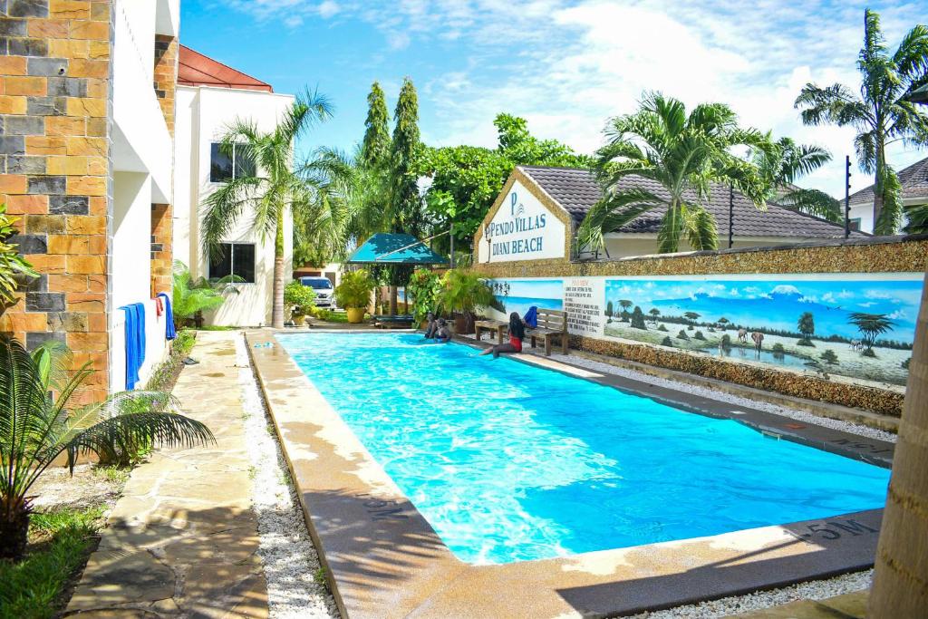 迪亚尼海滩Pendo Villas Diani Beach的大楼前的蓝色海水游泳池