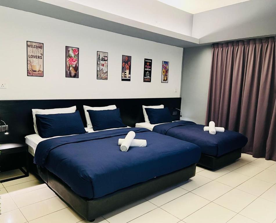 丹绒亚路M Suite Homestay, Aeropod Sovo Kota Kinabalu的两张位于酒店客房的床,配有蓝色床单