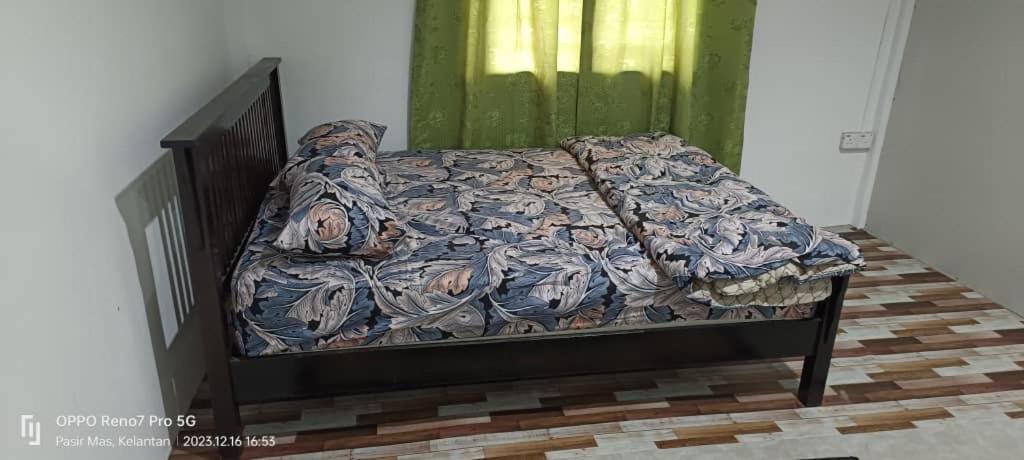 Pasir MasSobey Laris Homestay TENDONG的绿色墙壁间的一张床位