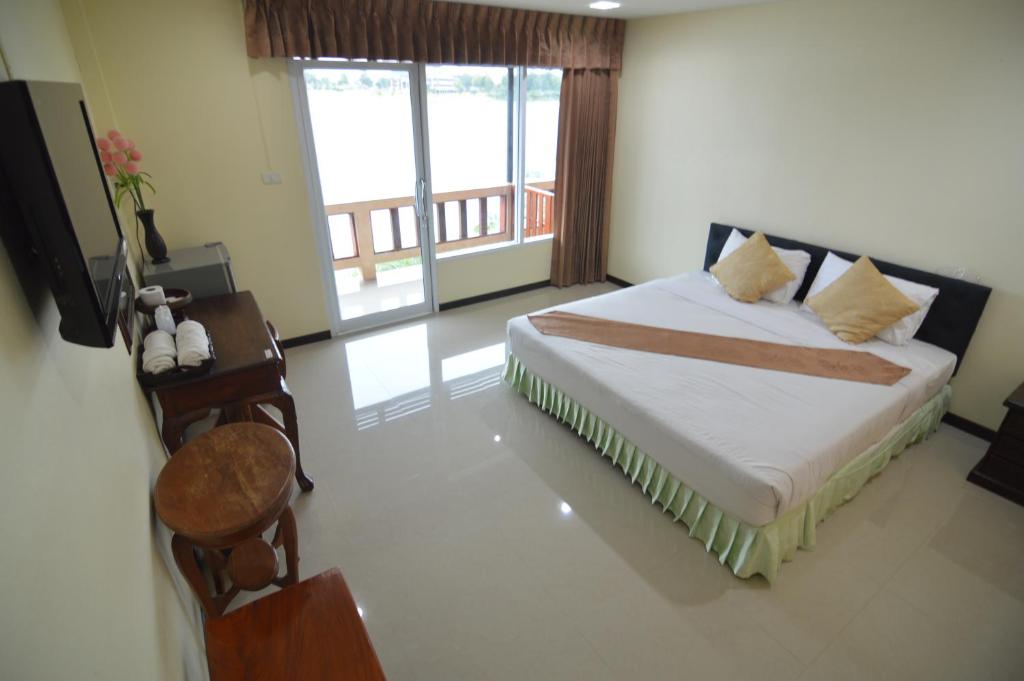 甘烹碧泰克诺江景度假酒店的一间卧室配有一张床、一张桌子和一个窗户。