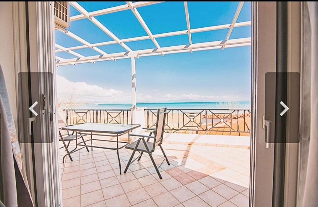卡塔科隆Κatakolo Luxury Seaside House & Garden的阳台享有海景,配有桌椅。