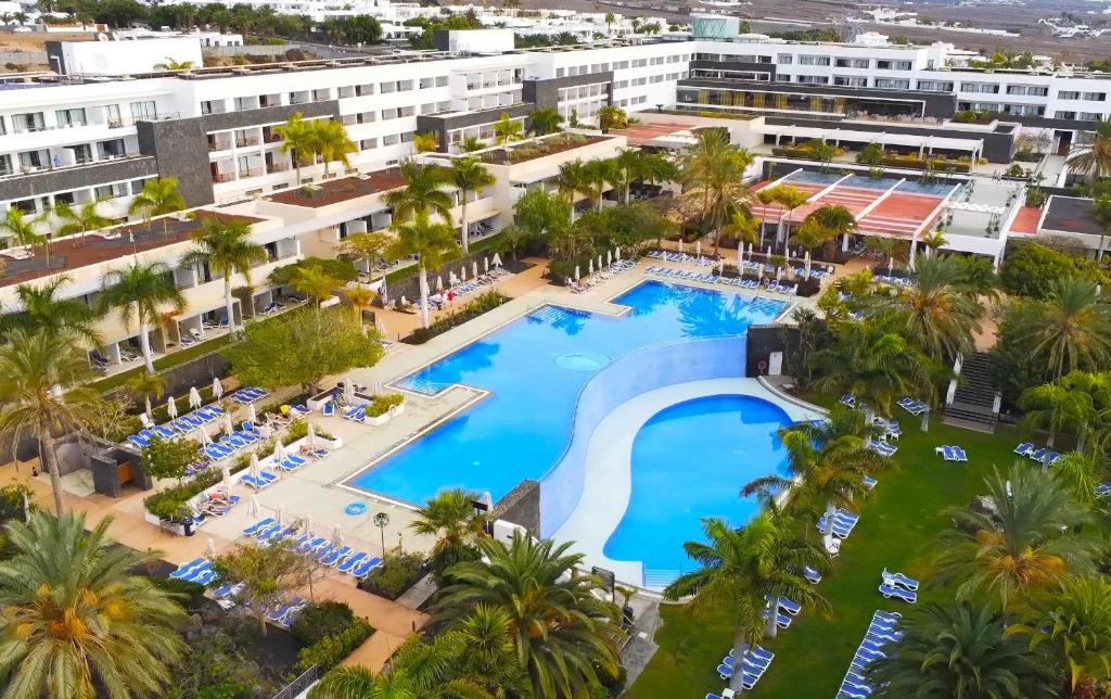 卡列罗港Hotel Costa Calero Thalasso & Spa的棕榈树度假村泳池的空中景致