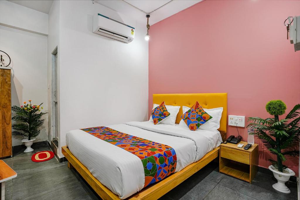 苏拉特FabHotel Sky City的一间卧室配有一张黄色床头板的床