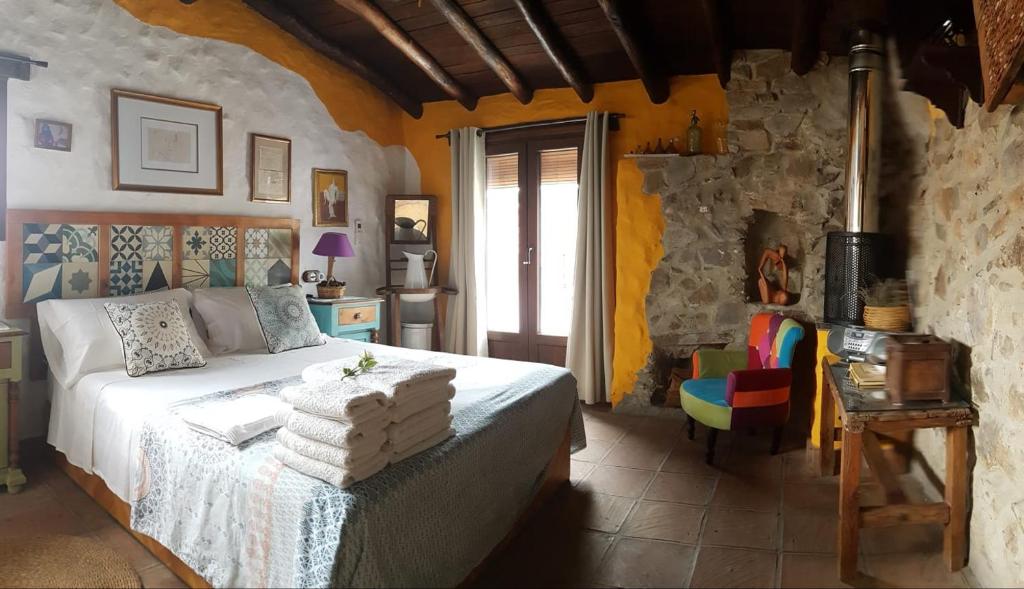 贝纳拉瓦Casa La Yedra by CasaTuristica的一间卧室配有一张床和一张桌子及椅子