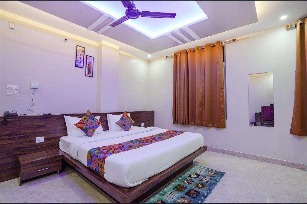 瓦拉纳西FabHotel Nandini Grand的一间卧室配有一张床和吊扇