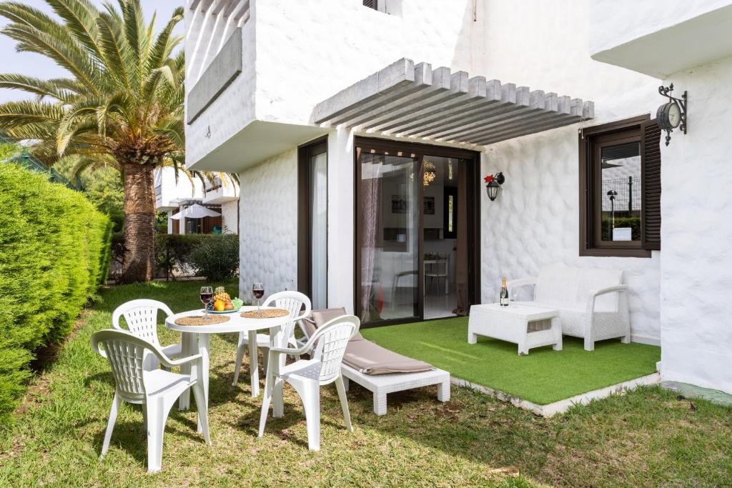 美洲海滩Nice apartment in the heart of Las Americas的绿色草坪上带桌椅的庭院