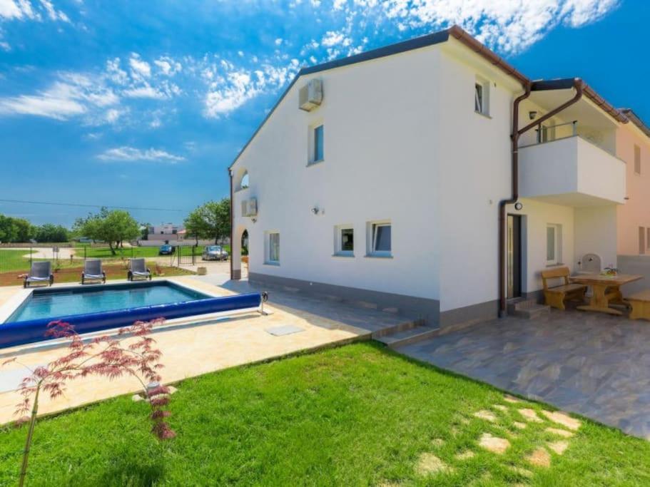 GajanaKuča Mira的一座白色的房子,在院子里设有游泳池