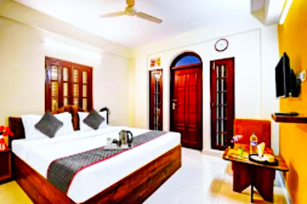 JojeraHotel Jheel Mahal New Town Inn West Bengal - Couple Friendly的一间卧室配有一张带水槽和红色门的床