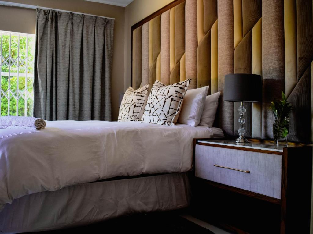 约翰内斯堡Serene Guest Manor的一间卧室设有两张床和窗户。