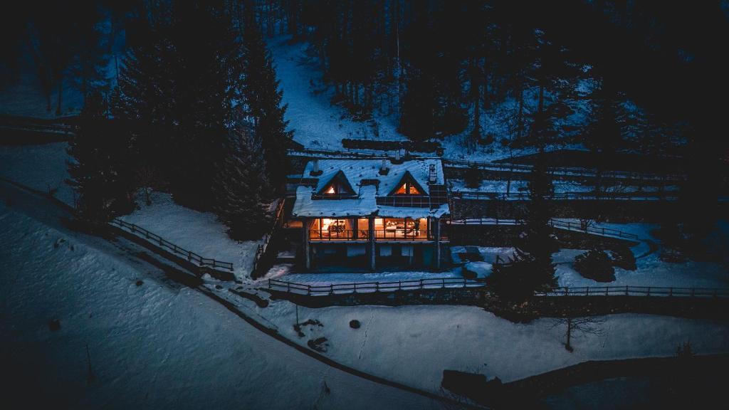 CrépinChalet Snostorm的夜晚在雪中看到房子的空中景色