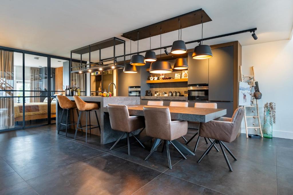 哈尔德韦克Het-Boothuys的开放式厨房配有木桌和椅子