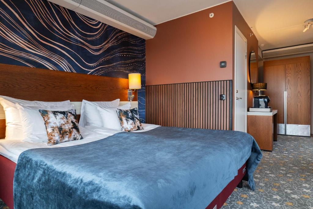哥德堡ProfilHotels Opera的酒店客房配有一张带蓝色毯子的大床