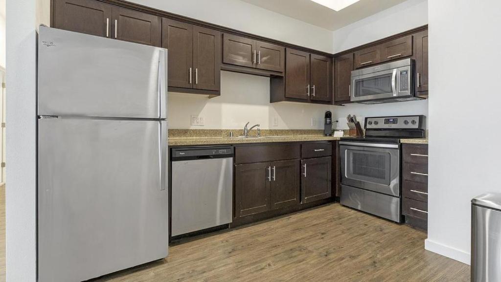 奥克兰Landing Modern Apartment with Amazing Amenities (ID1191X971)的厨房配有白色冰箱和木制橱柜。