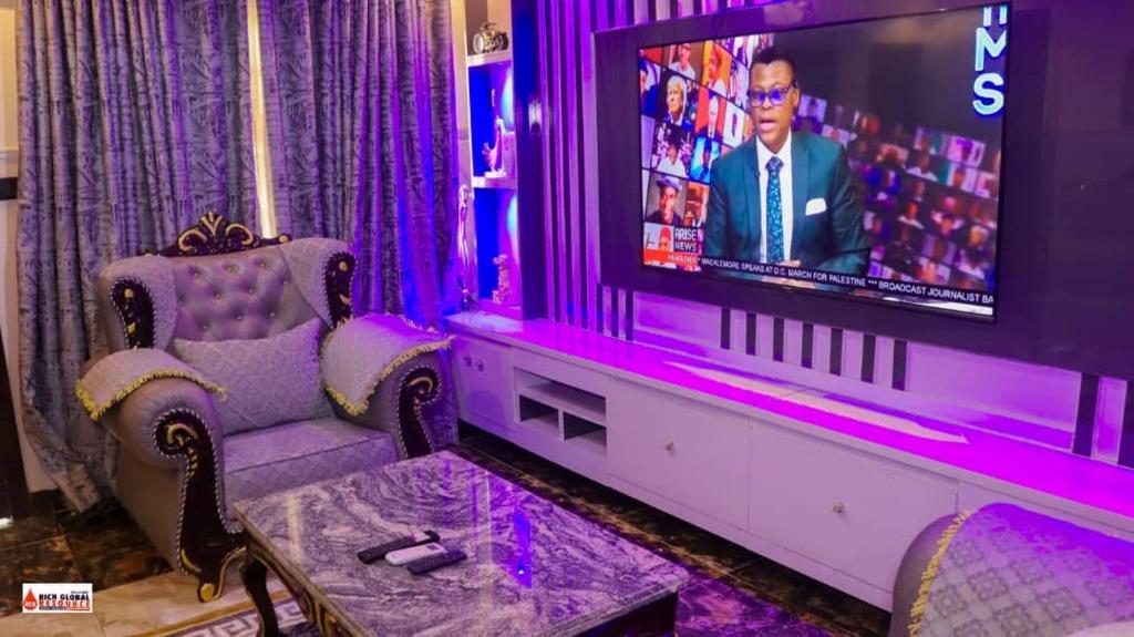 拉各斯Richard Magodo Apartment的客厅配有带紫色照明的电视