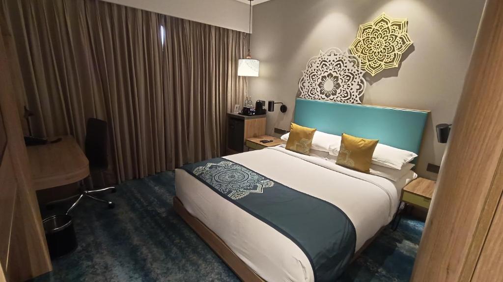 新德里Jupiter Gold Delhi Airport的一间卧室配有一张大床和蓝色床头板
