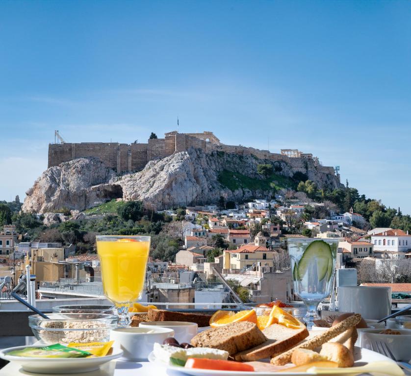 雅典Hotel Adonis Athens的一张桌子,配有面包和橙汁,享有鸡肉的景色