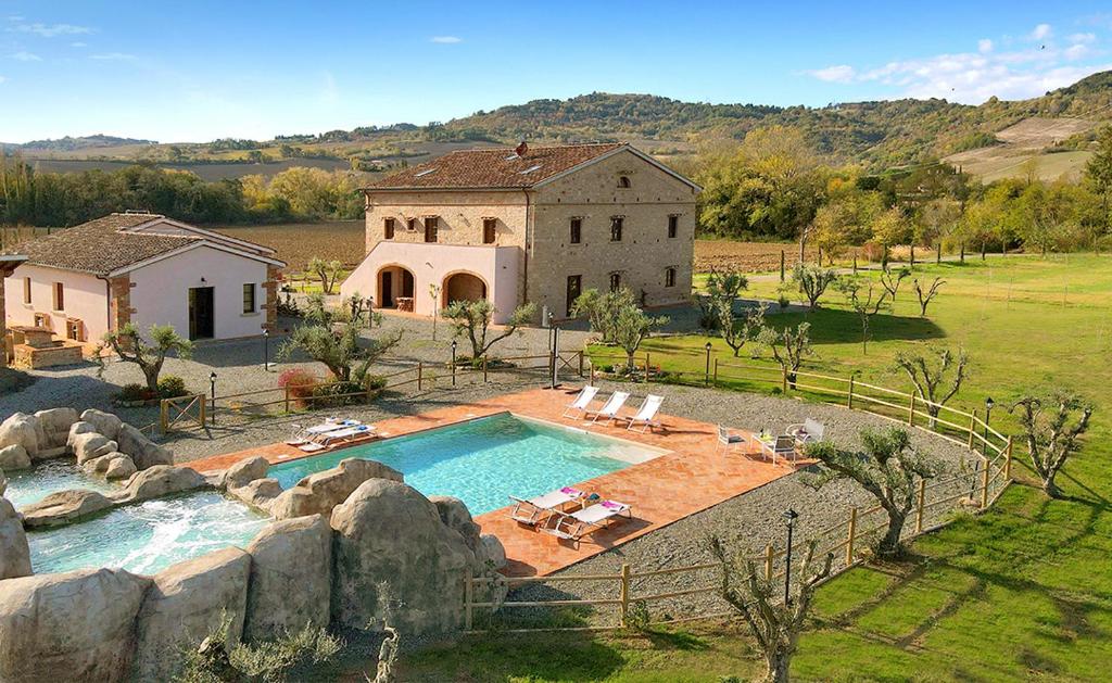 瓜尔迪斯塔洛Podere La Querciola的一座大房子,在院子里设有游泳池