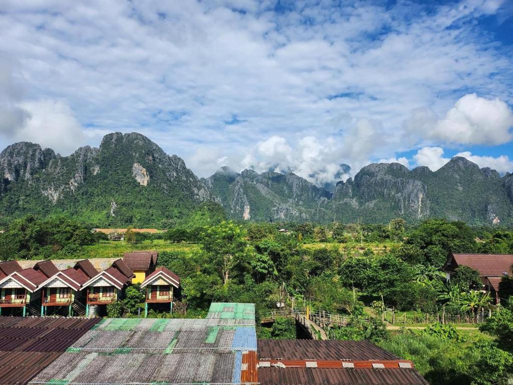 万荣Vang Vieng Sky Mountain View Hotel的享有带房屋和树木的山脉美景