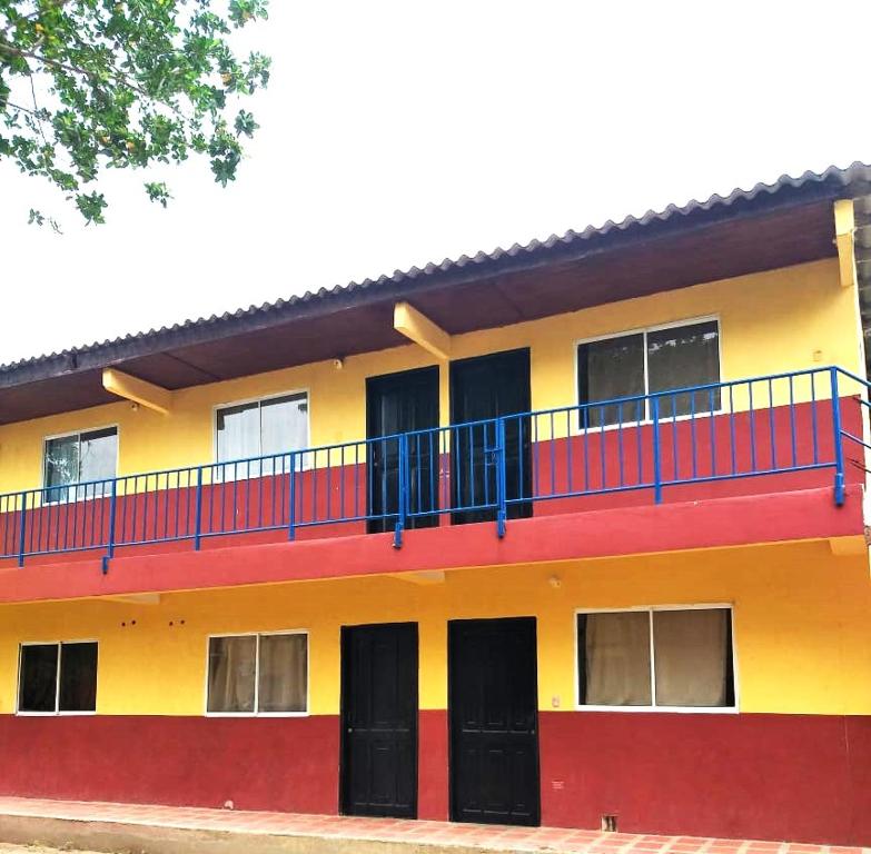 科韦尼亚斯Apartamentos Coveñas的红色黄色和蓝色的建筑,设有阳台