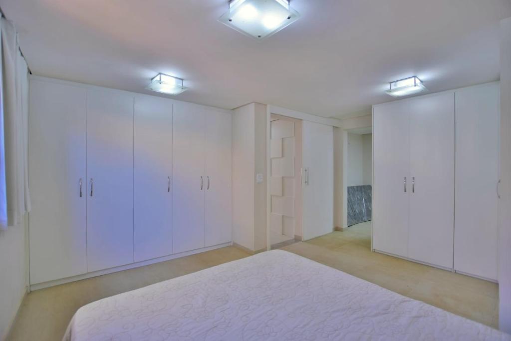 巴西利亚Chalé Lago Norte的一个空房间,有白色的橱柜和地毯