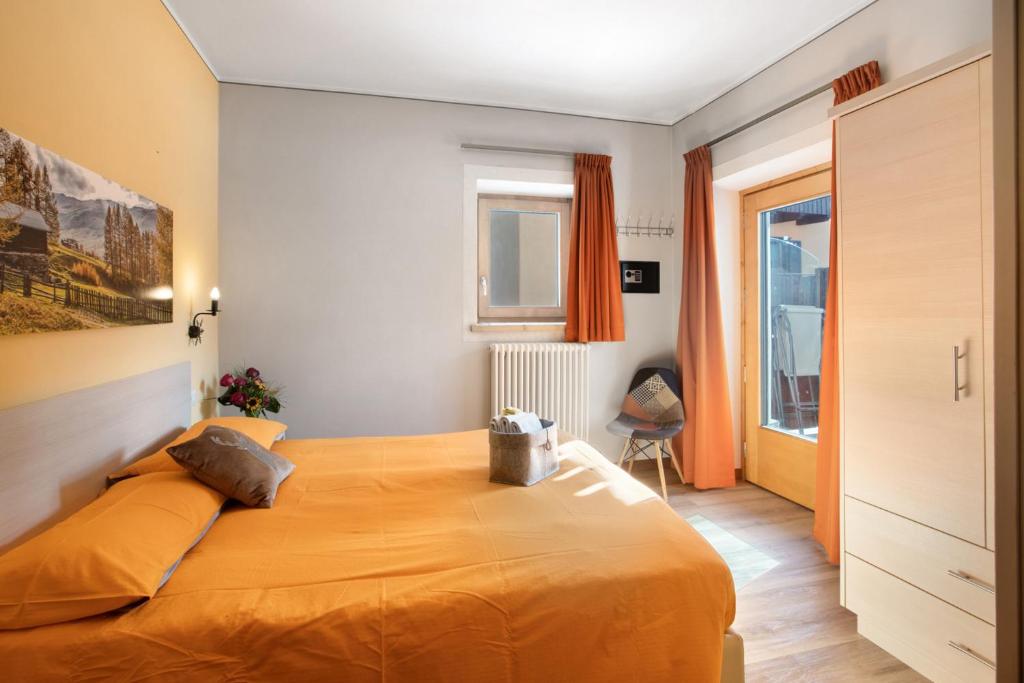 利维尼奥Mountain Apartments Livigno的一间卧室配有一张带橙色床罩的大床