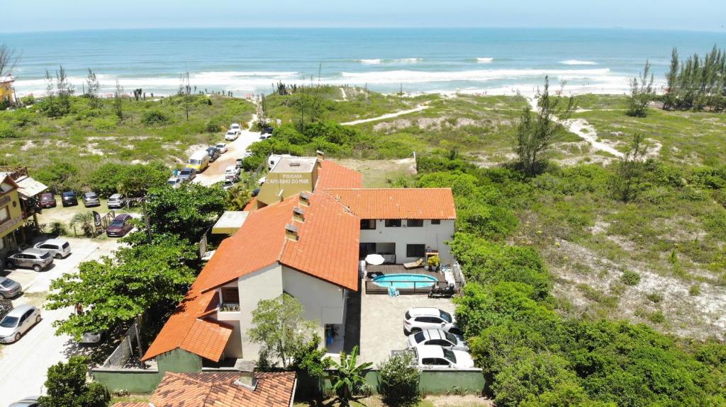 加罗帕巴Pousada Caminho do Mar MADHOUZE的房屋和海洋的空中景致