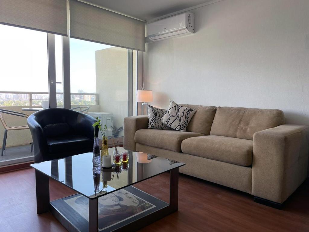 圣地亚哥Las Condes, Excelentes Apartamentos - Sofia Camilla Propiedades的带沙发和玻璃桌的客厅