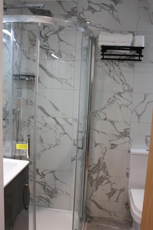 伦敦奥林匹亚酒店的浴室里设有玻璃门淋浴