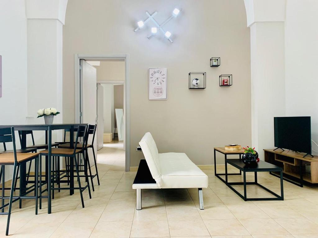 CarmianoTre Balconi - Casa Vacanza Salento的客厅配有桌椅和电视。