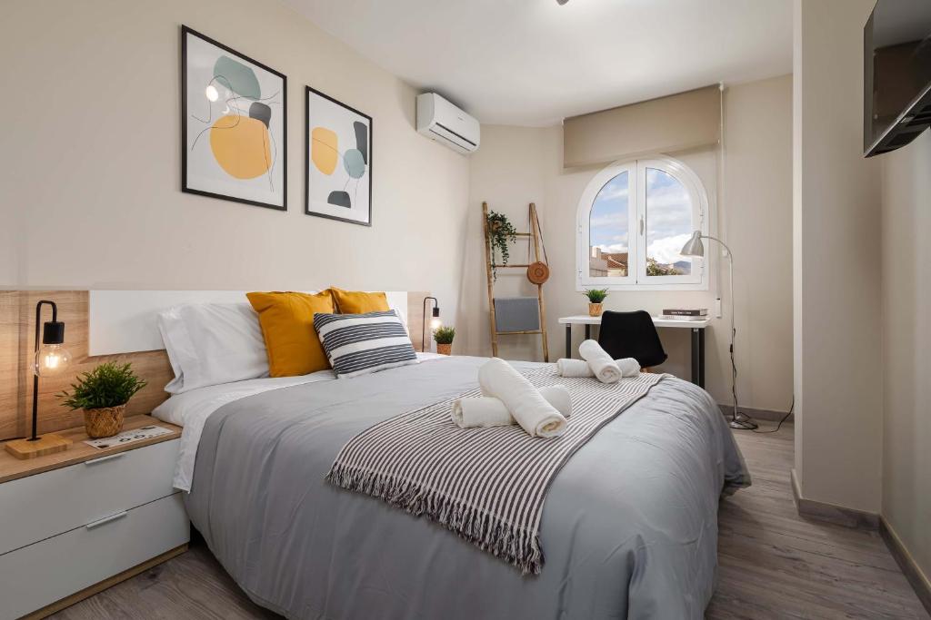 马拉加Nordik Rooms Urban - Segalerva "Geiranger"的一间卧室配有一张大床和两条毛巾