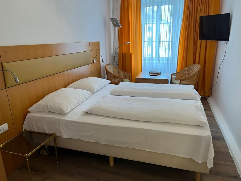 因河畔布劳瑙City Hotel Post 22的酒店客房设有两张床和电视。