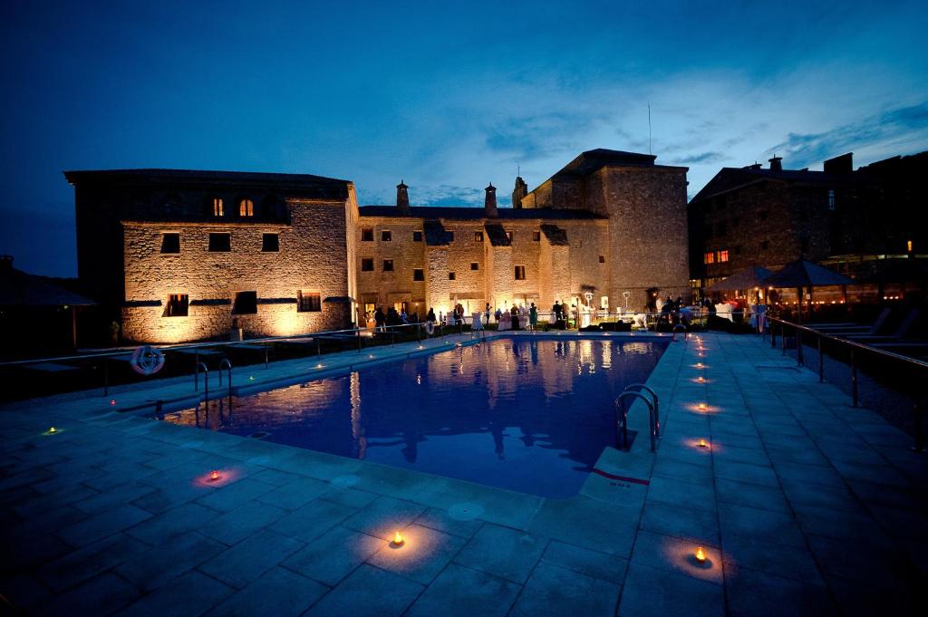 博尔塔纳Hotel & SPA Monasterio de Boltaña的城堡前的一个大型游泳池