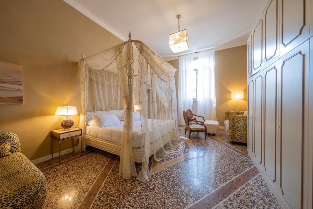 比萨Lungarno Buozzi 7 Apartments的一间卧室配有一张带天蓬的床