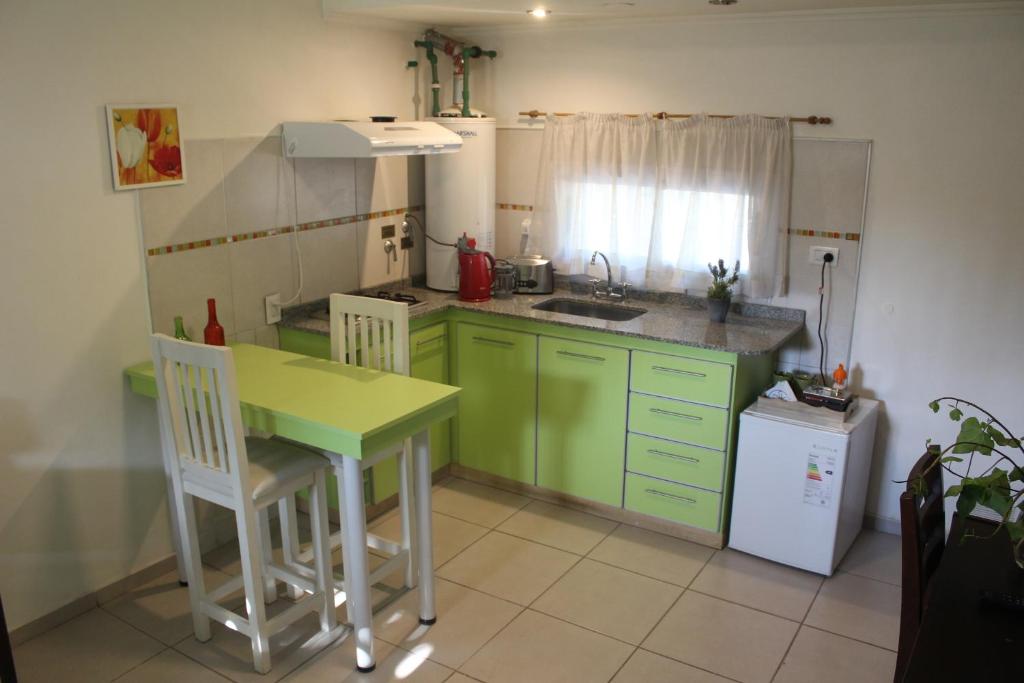 门多萨Departamento Encantador monoambiente Domaine Laborde I的厨房配有绿色橱柜、桌子和水槽