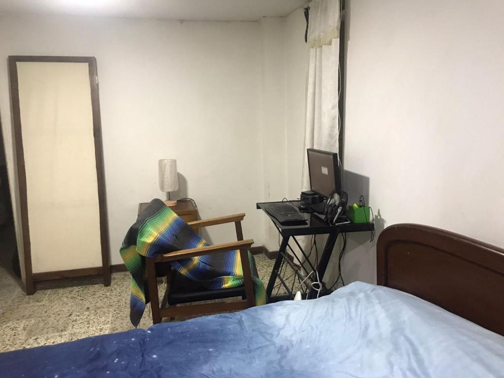 亚美尼亚CASA EN EL QUINDÍO的一间卧室配有一张床和一张带电脑的书桌