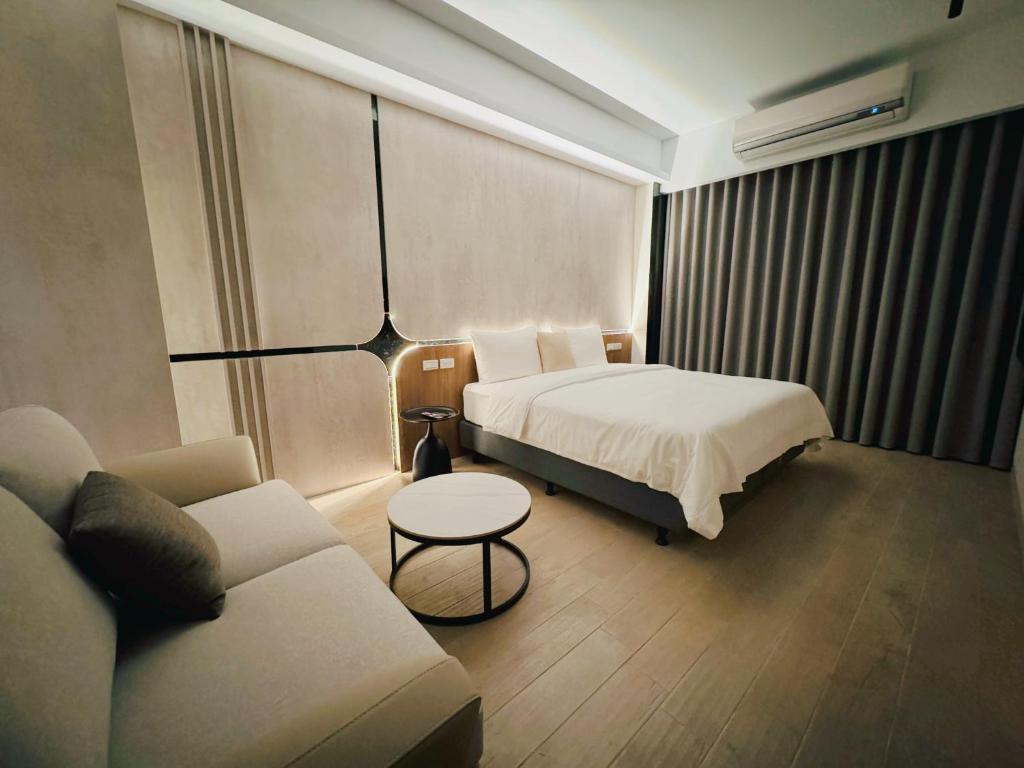 台南Enjoy Homestay的酒店客房,配有床和沙发