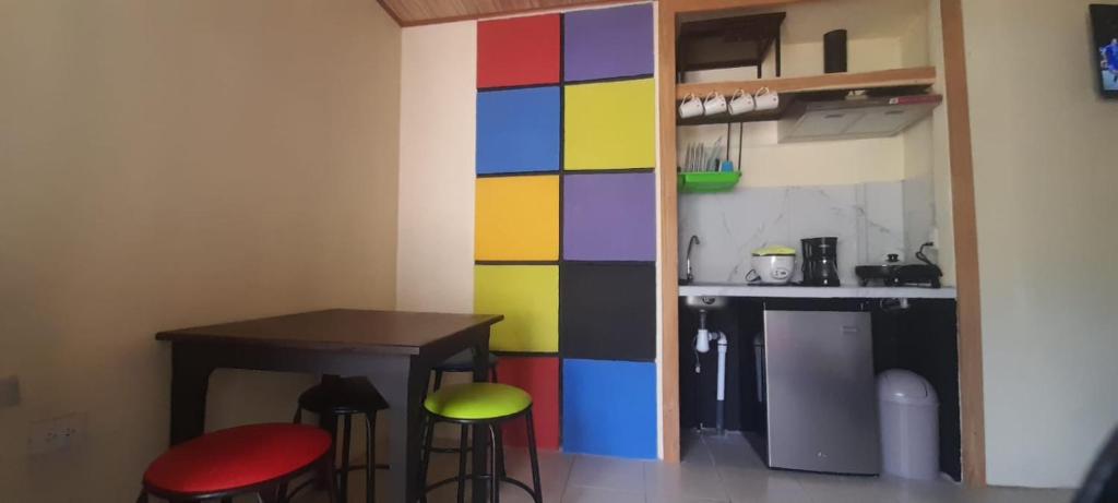 SavegreCabinas Rubik 1的厨房里色彩缤纷的墙壁,配有桌子和凳子