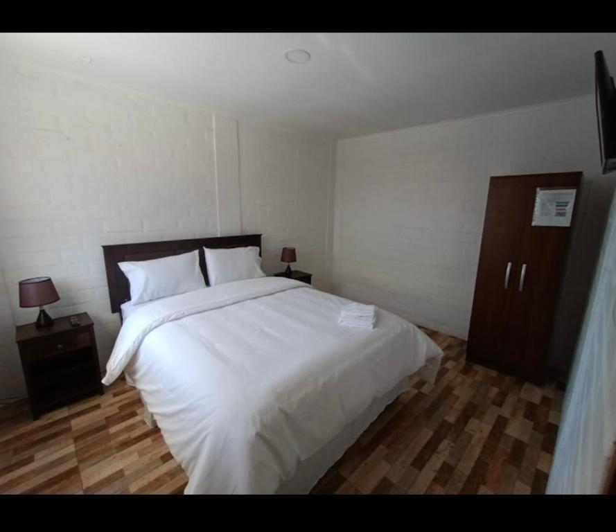 SalamancaHotel Santa Emilia Salamanca的卧室配有一张白色大床和2个床头柜