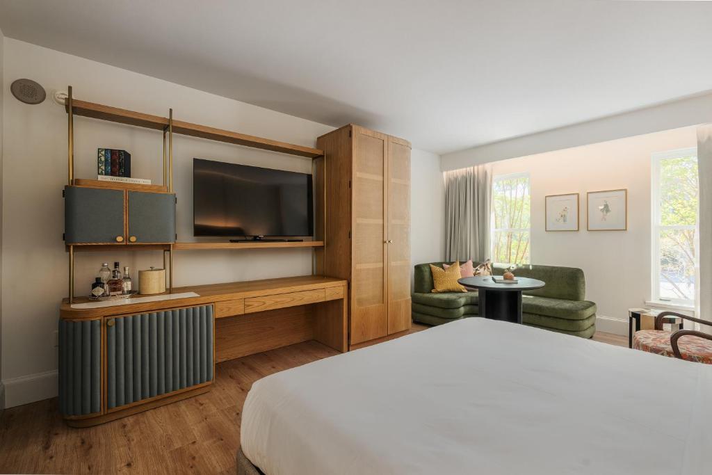 萨凡纳Hotel Bardo Savannah的配有一张床和一台平面电视的酒店客房