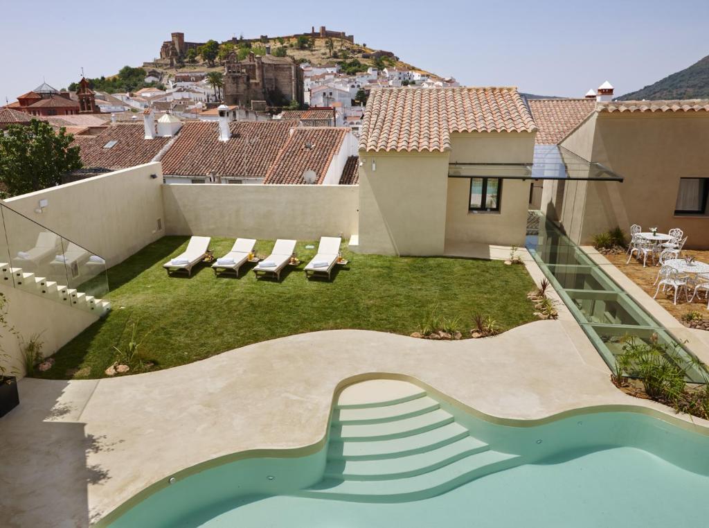 阿拉色那加莱里亚艾森提亚酒店的一个带游泳池和房子的后院