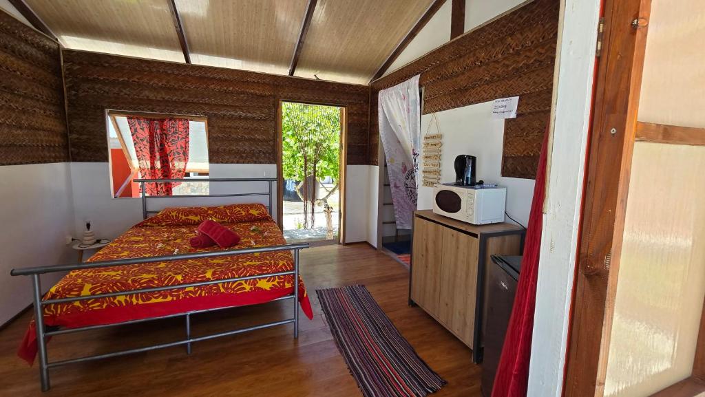 提克豪Tikehau HereArii Airbnb的一间设有床铺和微波炉的客房
