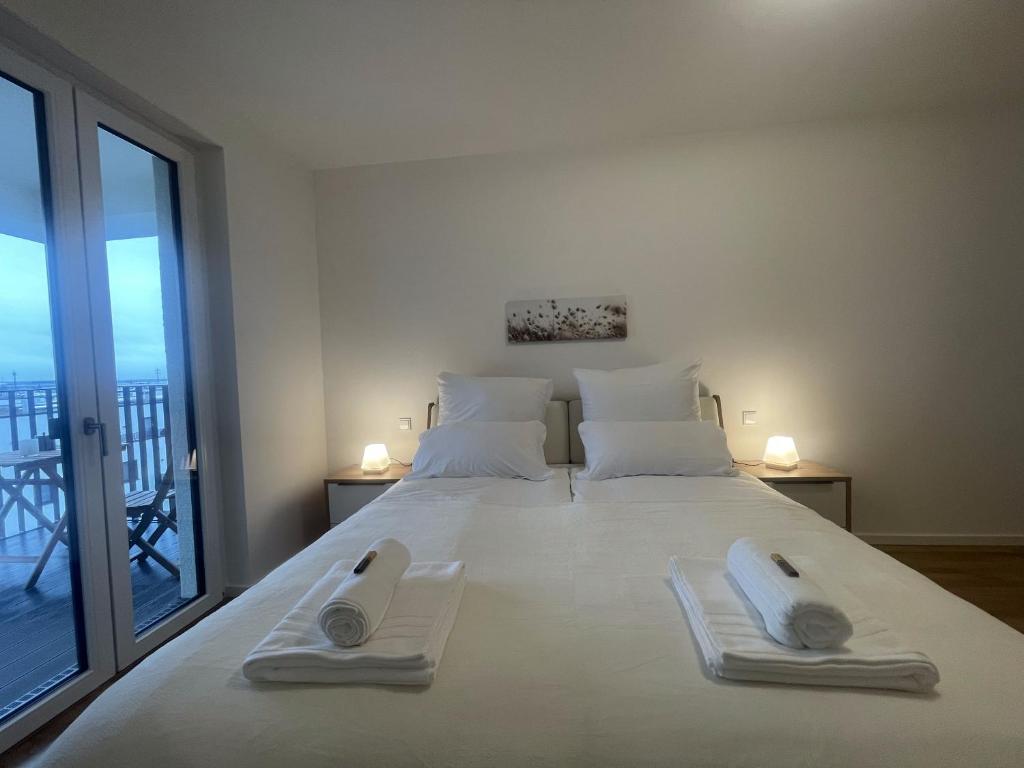 舍讷费尔德Luxurious and stylish apartment at BER Airport的卧室配有带毛巾的大型白色床