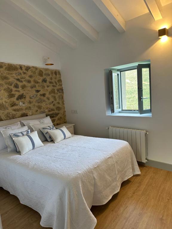 圣维森特-德拉巴尔克拉RUSTIC HOMES的卧室配有带枕头的大型白色床