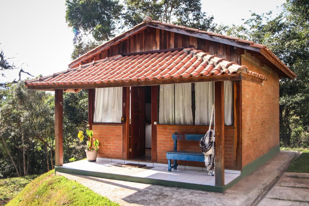阿尤鲁奥卡Pousada Estalagem Mirante的院子中带蓝色长椅的小棚子