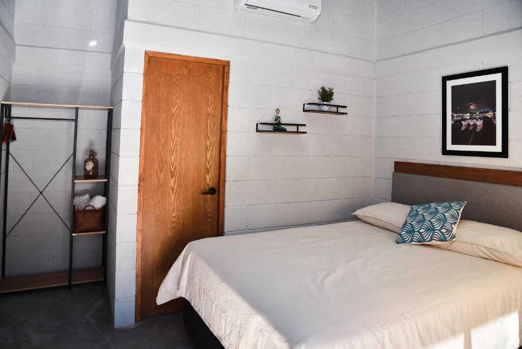 TopolobampoSealion Dive Center的一间卧室配有一张床和一扇木门